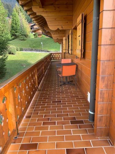 an outdoor balcony with a table and chairs on it at Magnifique chalet appartement à Villars, vue sur les alpes in Villars-sur-Ollon