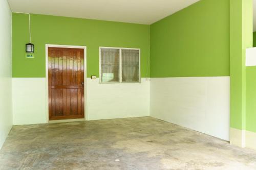 a room with green and white walls and a door at SriRungRueng Place in Kanchanaburi