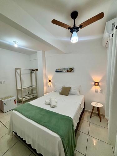 a bedroom with a bed with a ceiling fan at Pousada Escotilha in Arraial do Cabo