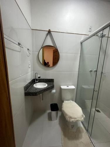 Un baño blanco con lavabo y espejo. en Apartamentos em Parintins, en Parintins