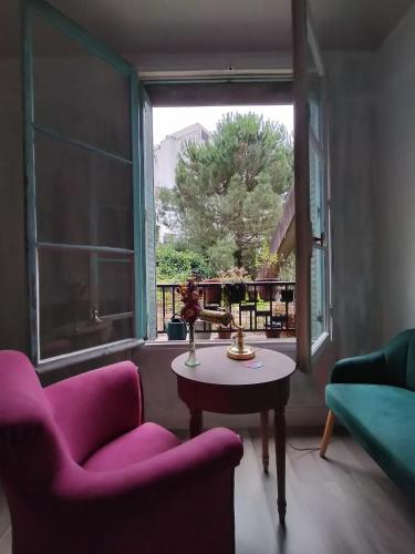 - un salon avec une table, 2 chaises et une fenêtre dans l'établissement Appartement T3 lumineux et cosy, à Paris