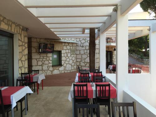 a restaurant with red chairs and tables on a patio at Pansion Ruža in Novi Vinodolski