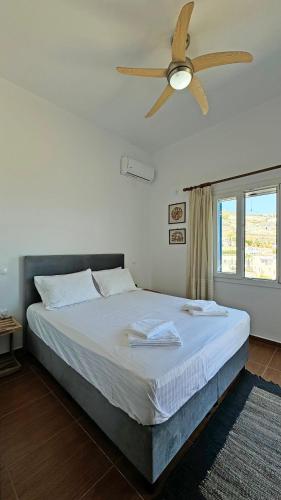 a bedroom with a bed with a ceiling fan at Lighthouse View Maisonette in Azolimnos Syros