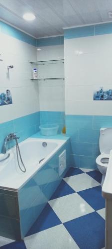 a blue bathroom with a tub and a toilet at Cléopâtre in Tefeschoun