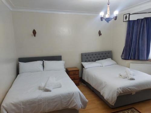 two beds sitting next to each other in a bedroom at Cosy Greener Private room in Pinner