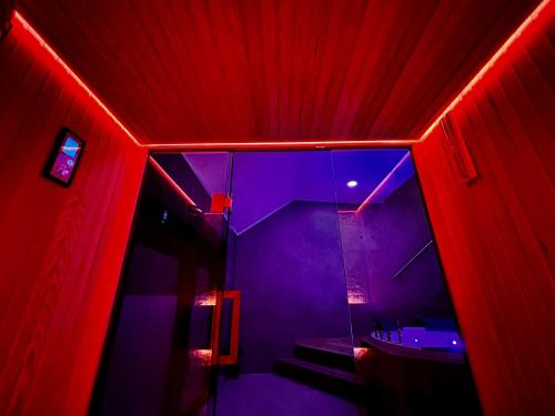 a red and purple bathroom with a sink and a mirror at Pause Thermale Suites Deluxe et Spa Privatif in Herstal