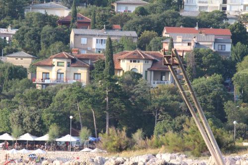 a group of houses on a hill next to a beach at Pansion Ruža in Novi Vinodolski