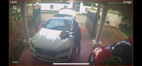 a person is standing next to a white car at La Casa Trivandrum 4 BHK AC Luxury Villa at City Centre, Just 5 kms from Airport & 3 Kms to Trivandrum Railway Station in Trivandrum