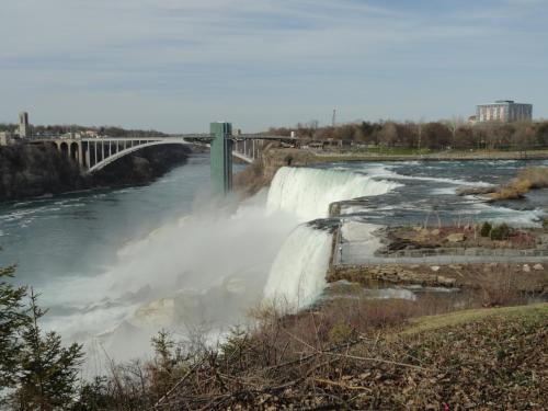 a waterfall on a river with a bridge at Rainbow Bed & Breakfast in Niagara Falls