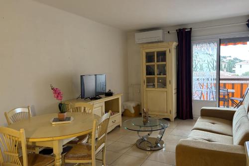 un salon avec une table et une télévision dans l'établissement Nest with 2 terraces open views on two sides, à Saint-Raphaël