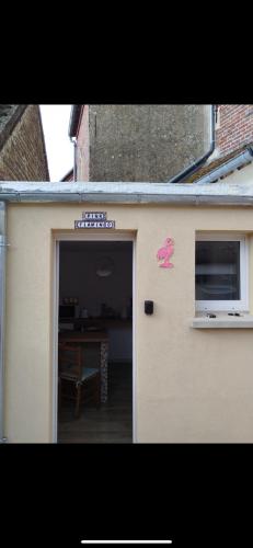 a door with a pink butterfly on the side of a building at maison pink flamingo aeroport tillé 2 a 4 personnes in Tillé