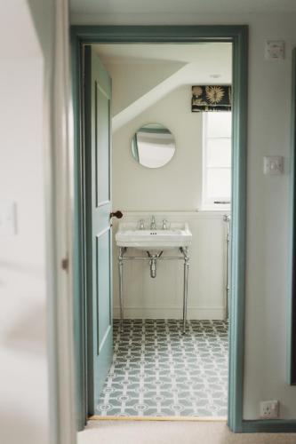 a bathroom with a sink and a mirror at Cotswolds Manor Gatehouse with Log Burner in Bredon