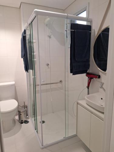a bathroom with a shower and a toilet and a sink at Studio Butantã Novíssimo in São Paulo