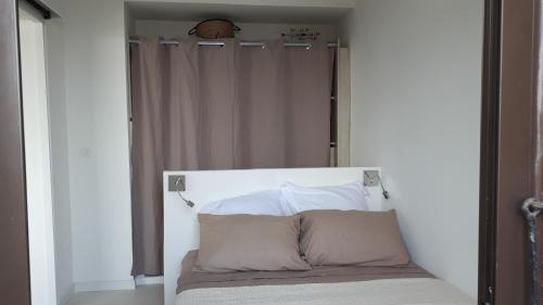 - un lit avec une tête de lit blanche dans une chambre dans l'établissement Maison bord de mer Marine de San't Ambroggio, à Lumio