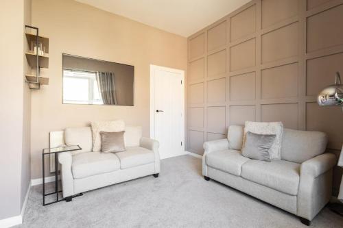 a living room with two chairs and a mirror at Host & Stay - High Street in Loftus