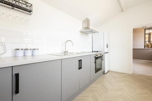 a kitchen with white cabinets and a sink at Host & Stay - High Street in Loftus