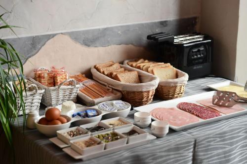 a buffet with bread and other foods on a table at Little Italy Hostel Ex Chiesa S Donato in Perugia