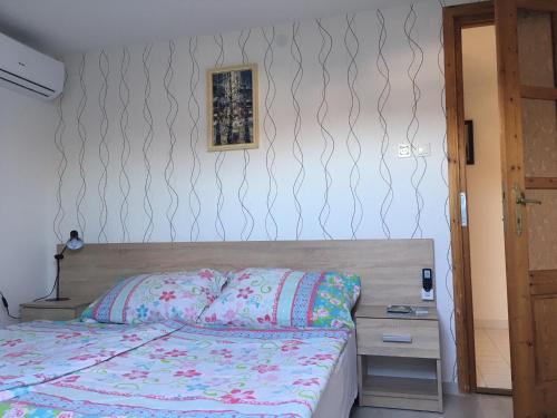 a bedroom with a bed and a nightstand next to a bed sidx sidx sidx at Katalin Vendégház in Gyenesdiás