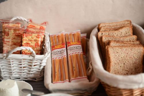 a table with two baskets of sandwiches and bread at Little Italy Hostel Ex Chiesa S Donato in Perugia
