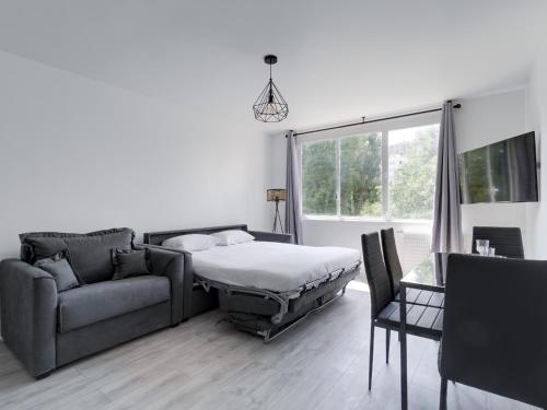 une chambre avec un lit, un canapé et une fenêtre dans l'établissement Grand Studio proche Stade de France, 3 pax, à Saint-Denis