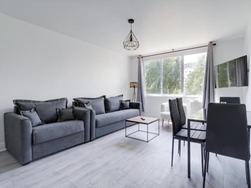 un salon avec un canapé et une table dans l'établissement Grand Studio proche Stade de France, 3 pax, à Saint-Denis