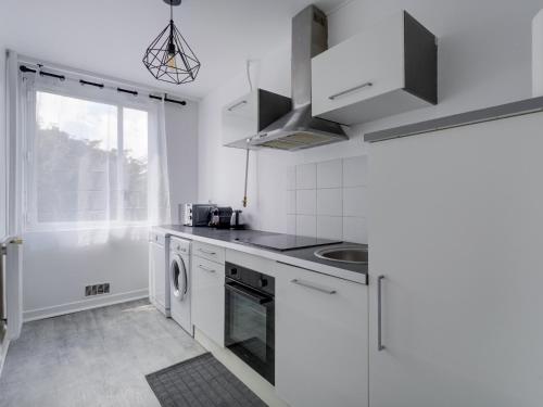 une cuisine blanche avec un évier et un lave-vaisselle dans l'établissement Grand Studio proche Stade de France, 3 pax, à Saint-Denis