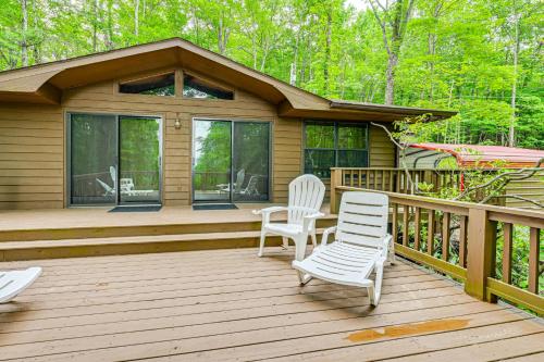a wooden deck with two chairs and a house at Smoky Mountain Cabin with Fire Pit and Stunning Views! in Andrews