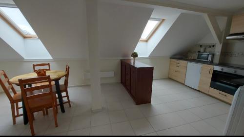 una cocina con mesa y una cocina con tragaluces. en Zöldfa Apartmanház - Tetőtér, en Eger