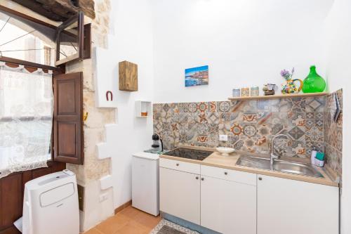 a kitchen with a sink and a counter top at Casa Ariadne by Ortigia Apartments in Syracuse