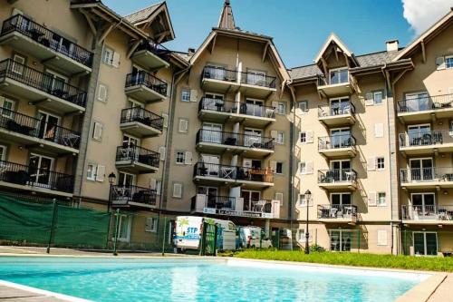 un immeuble d'appartements avec une piscine devant dans l'établissement Appartement ST GERVAIS 6pers Piscine, à Saint-Gervais-les-Bains