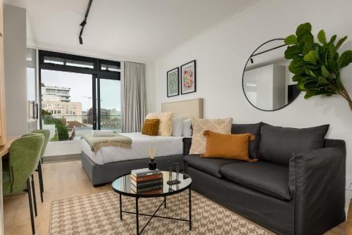 una sala de estar con un sofá y una mesa en The Sage Luxury Apartment Hotel, en Ciudad del Cabo