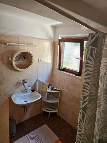 a small bathroom with a sink and a mirror at MONTEFIN HOUSE in Petrovac na Moru
