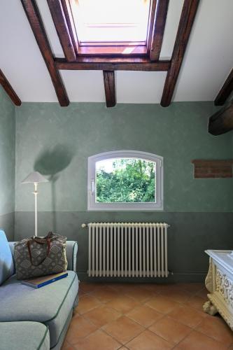 a living room with a couch and a window at Elizabeth Country House, a Member of Design Hotels in Minerbio