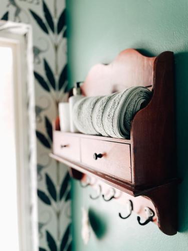 a wooden shelf with towels and a mirror at Beckenham Place in Durban