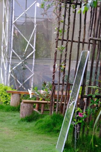 a greenhouse with a wooden table and a bench at Amikaje Farm in Xuan An