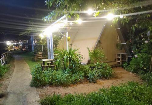a patio at night with a table and plants at Amikaje Farm in Xuan An