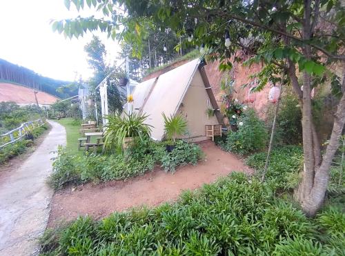a small building with a table and bench next to a road at Amikaje Farm in Xuan An