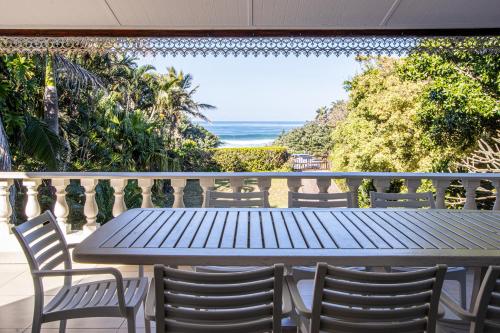 una mesa azul y sillas en un balcón con vistas al océano en Seanique Holiday Home, en Margate