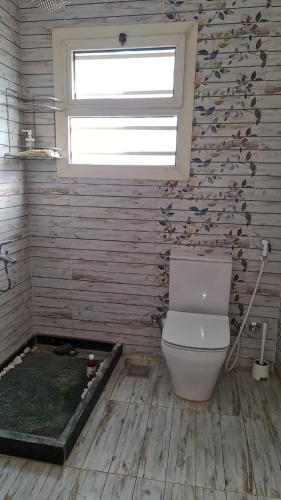 a bathroom with a toilet and a window at New venisia Resort in Ain Sokhna
