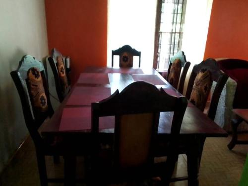 a dining room table and chairs with a wooden table at Full Home Busia at Nambale Gated Wifi and Electricity in Nambale