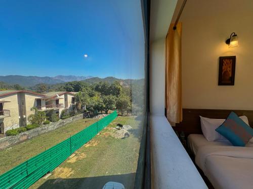 una camera con balcone con vista sulle montagne di Shelton Blu Resort Jim Corbett a Ramnagar