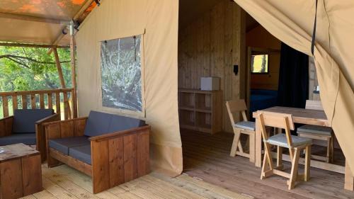 a tent with a table and chairs on a deck at Glamping Podere Angiotto LODGE LAVANDA in Magliano in Toscana