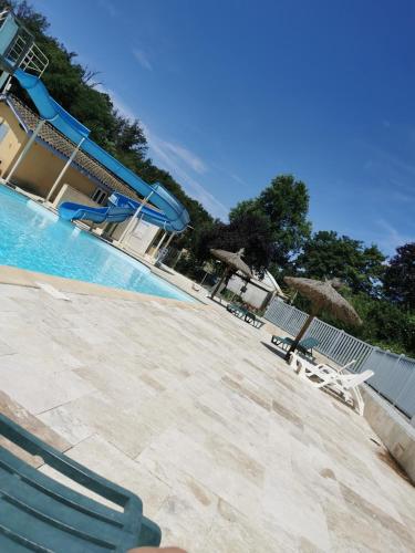 - une piscine avec 2 chaises et un toboggan dans l'établissement Bungalow camping 3 étoiles, à Chazelles-sur-Lyon