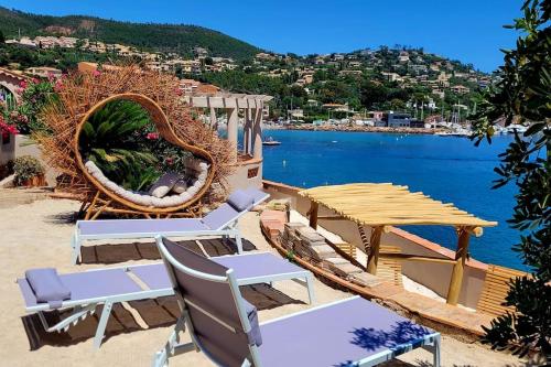 un groupe de chaises et de tables sur une plage dans l'établissement Villa de prestige en bord de mer dans la baie de Cannes, à Théoule-sur-Mer
