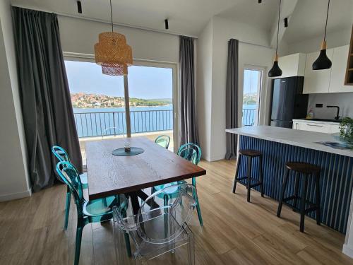 a kitchen with a table and chairs with a view of the ocean at Villa LUX Apartments in Rogoznica