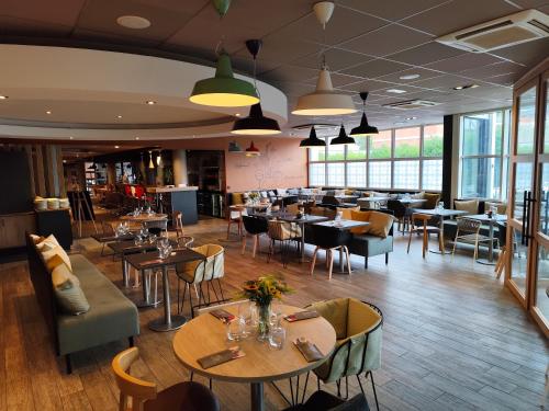 a restaurant with tables and chairs and a bar at ibis Le Havre Centre in Le Havre