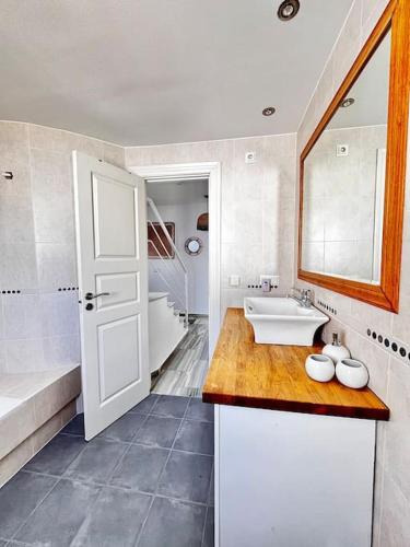 a bathroom with a sink and a tub and a mirror at Apartamento Lagarto in Sitio de Calahonda