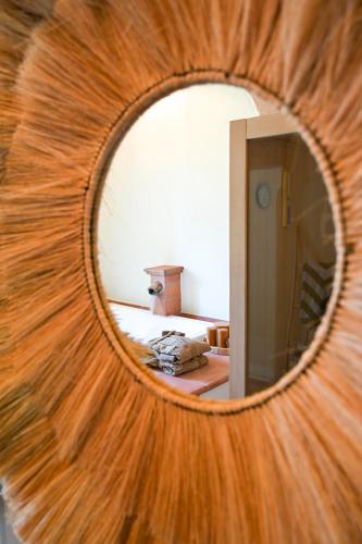 a mirror reflecting a bedroom with a bed in a room at Elizabeth Country House, a Member of Design Hotels in Minerbio