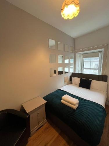 a bedroom with a bed with two towels on it at Latin Quarter Townhouse in Galway