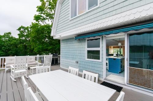 a deck with a white table and chairs on a house at Spacious 3BR Sunset Island Beach House in Wareham